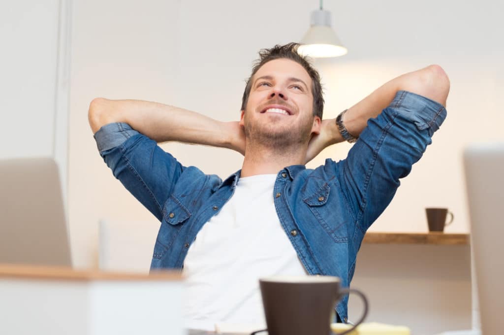 a happy young man relaxing after finding the right apartment