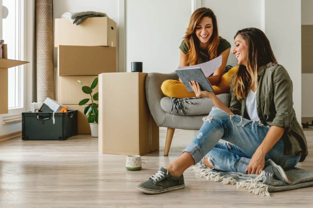 Two millennial women moving into their new apartment