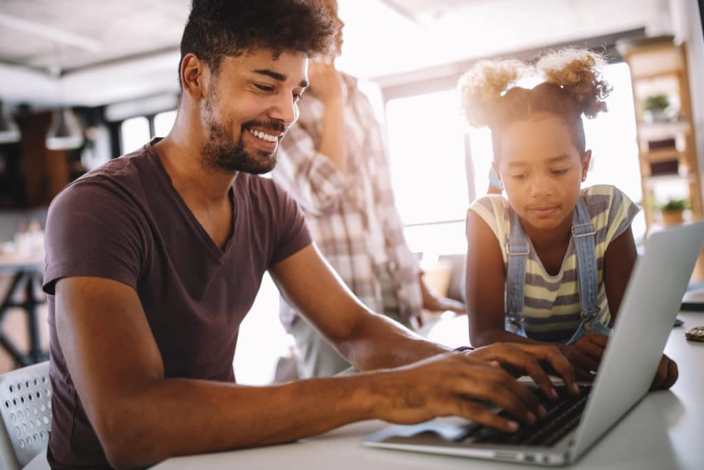 Father and daughter working on laptop. Businessman working from home and watching child