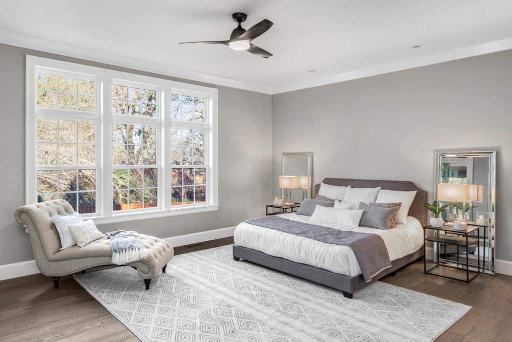 A beautiful bedroom with a large bed and big, wide windows.