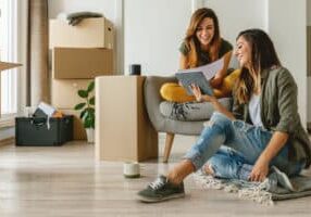 Two millennial women moving into their new apartment