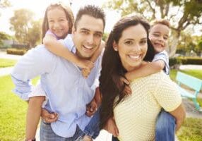a happy hispanic family smiling outside of their apartments for rent
